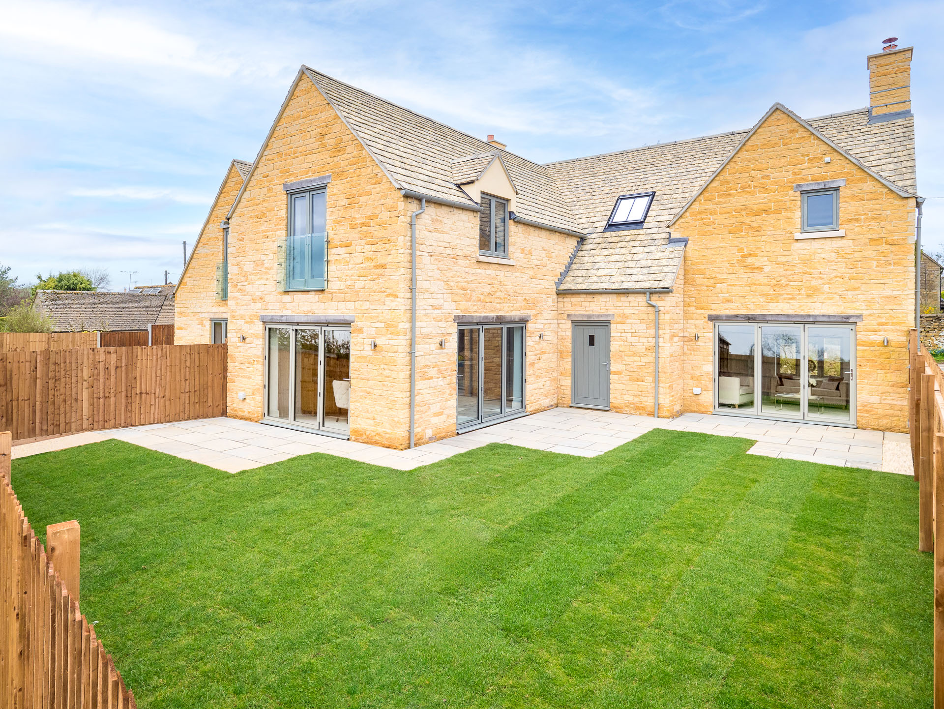 Back of house with patio and grass area and three sets of patio doors