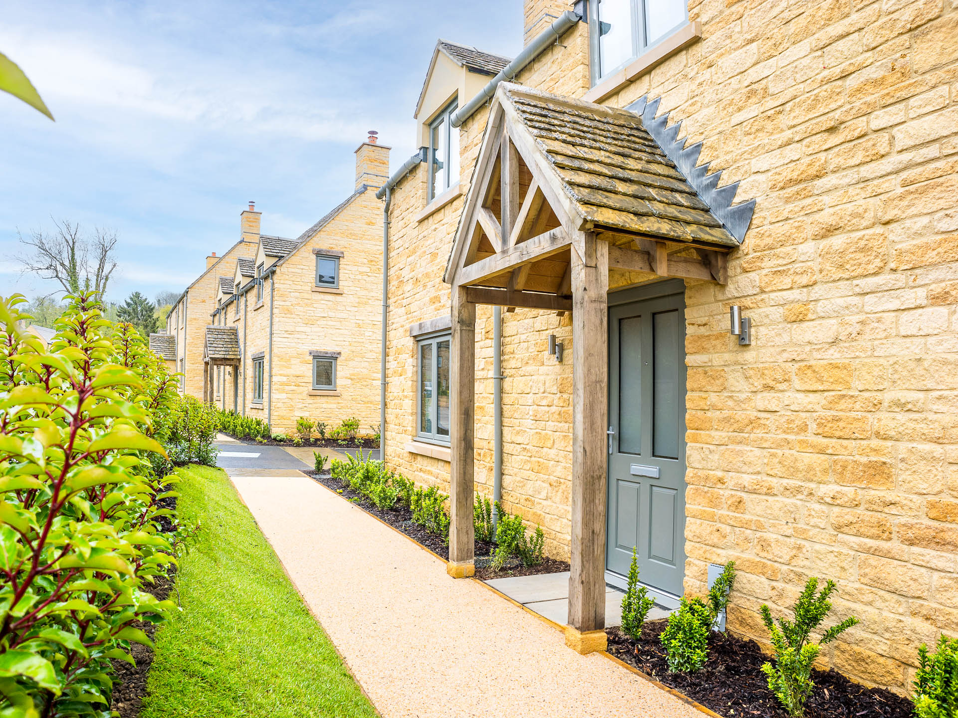 Front of house with grey doors and windows and a pathway