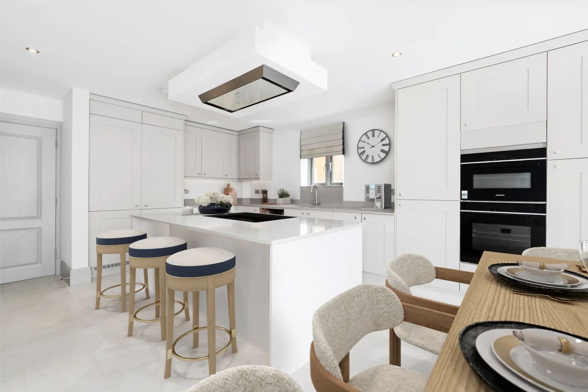 White kitchen with island, oak dining table and silver hardware