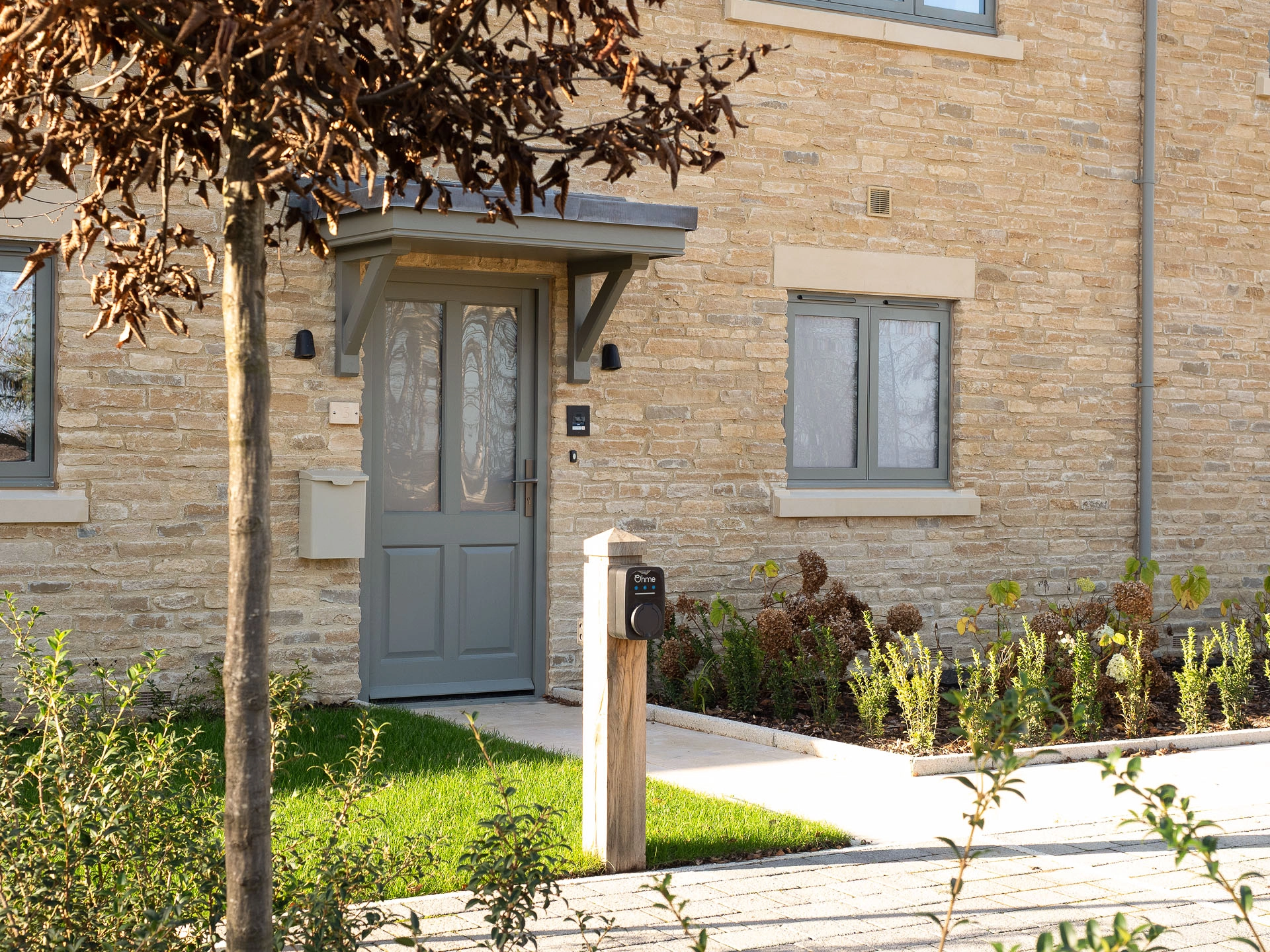 Home with a grey front door and small plants out of the front