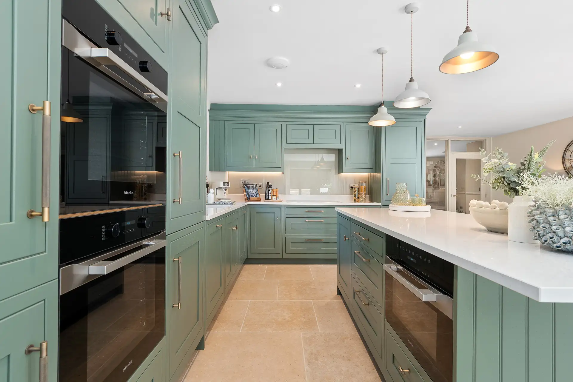 Green kitchen with double oven and copper hardware