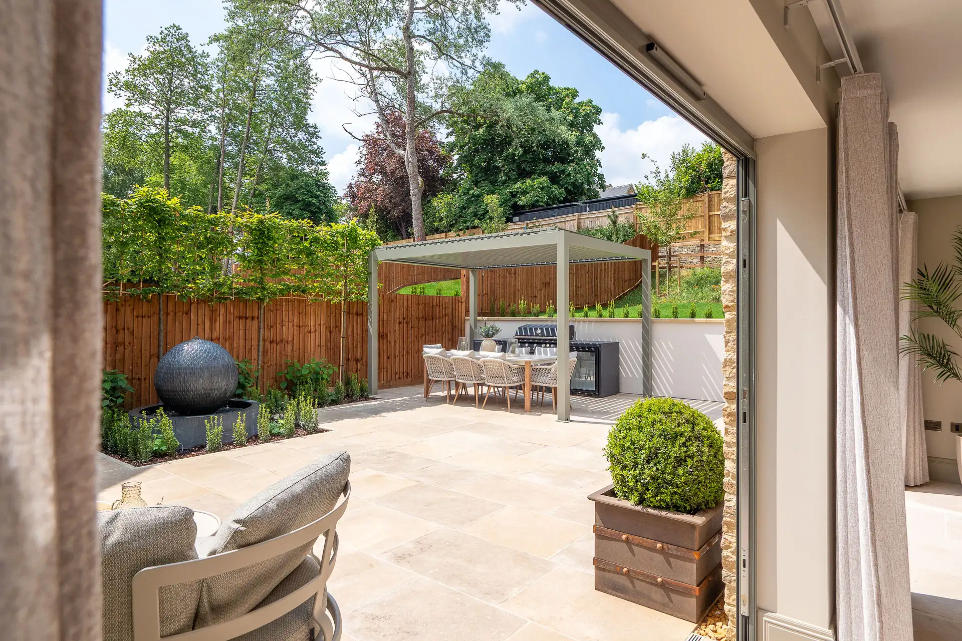 Garden patio with covered area for table and barbeque, light patio tiles