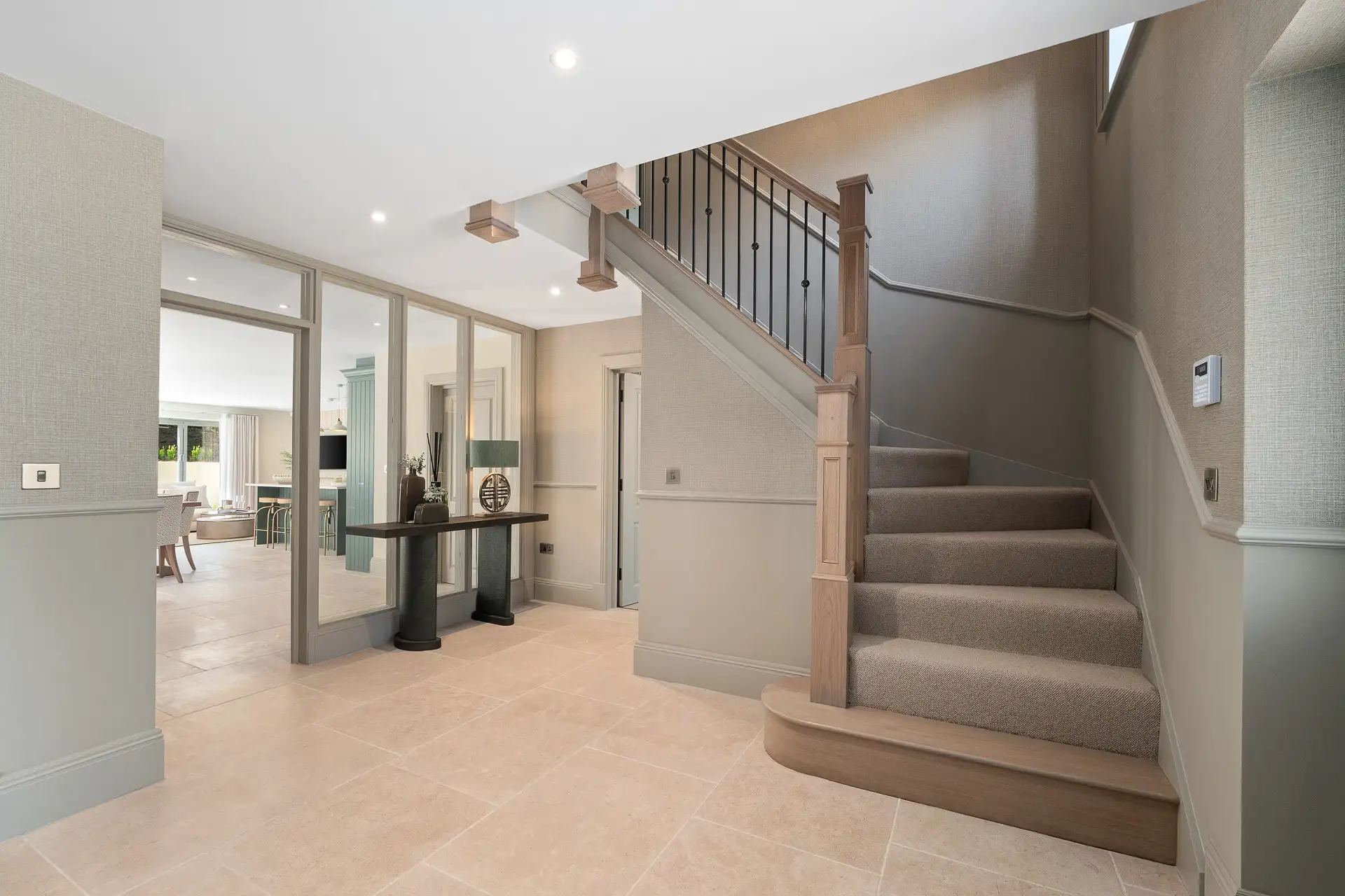 Entrance with glass walls, curved staircase and panelling