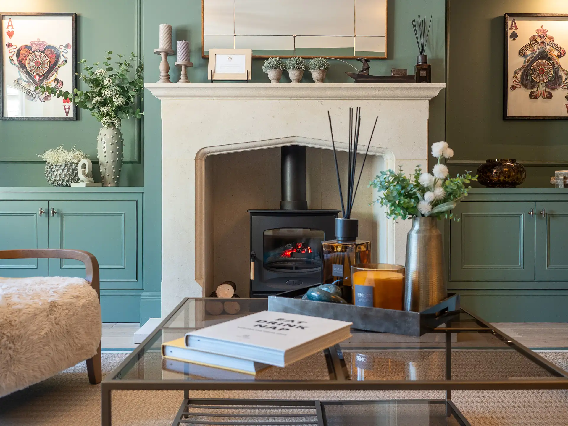 Close up photo of fireplace and green built in cupboards in living room