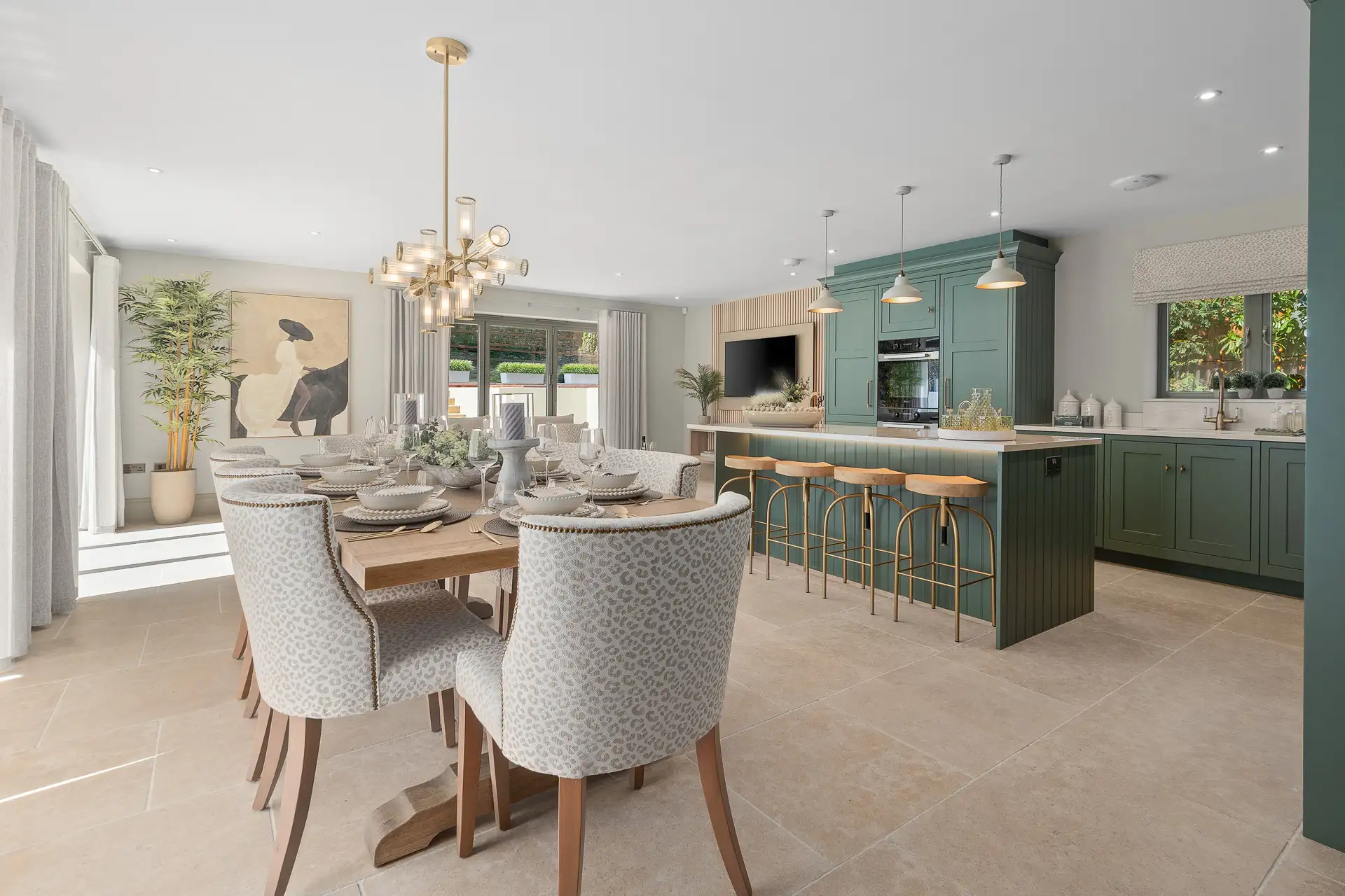 Open plan kitchen in a green colour with an island and leopard print chairs