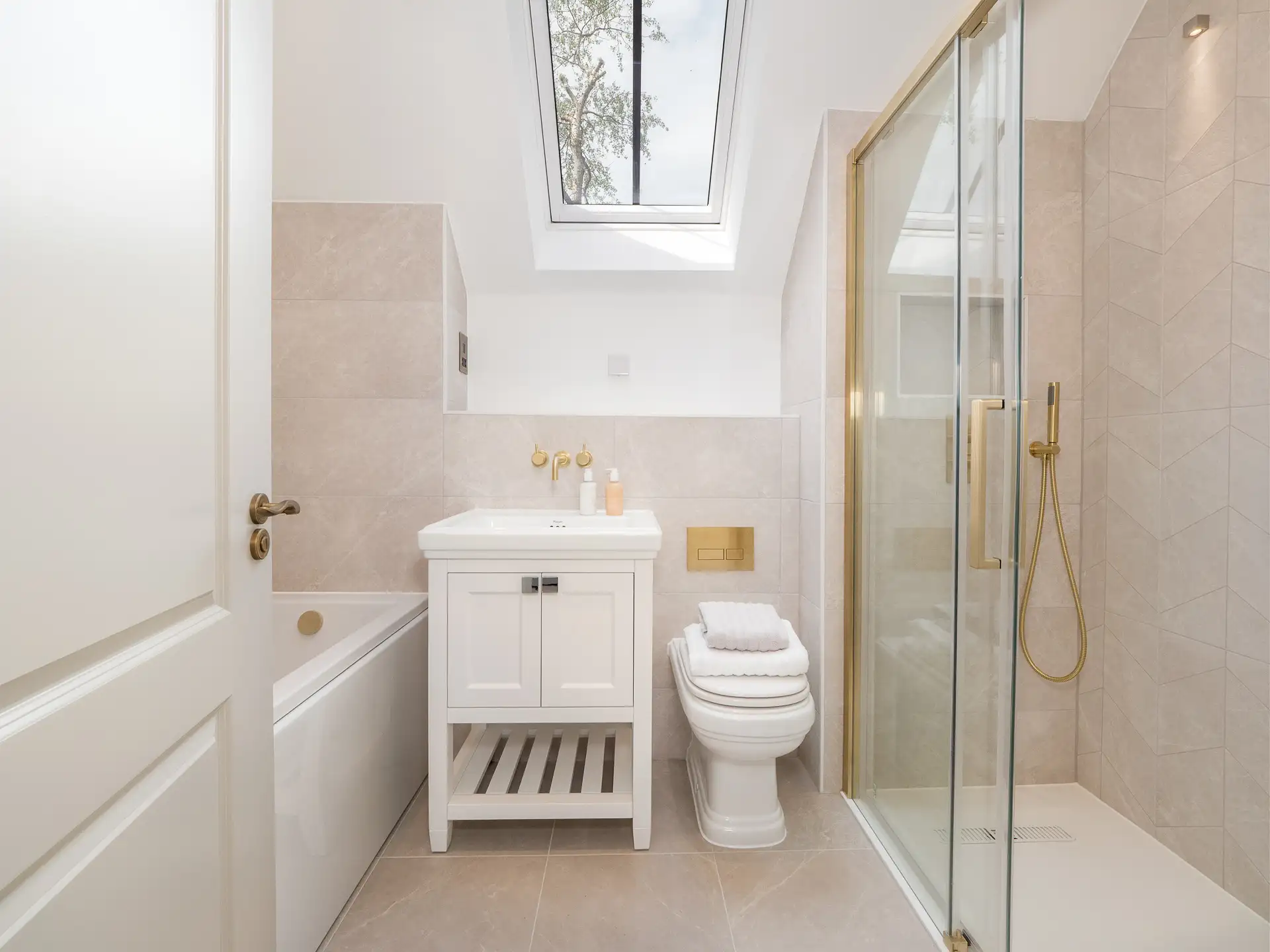 Bathroom with gold hardware and white under sink cupboard