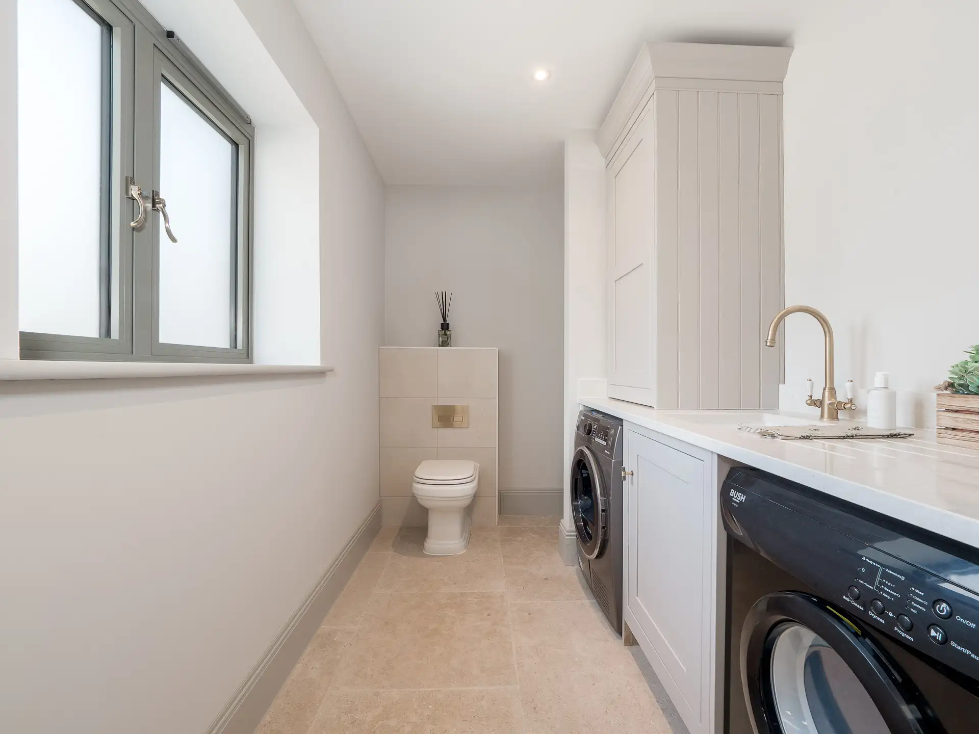 Bathroom combined with utility room with gold hardware