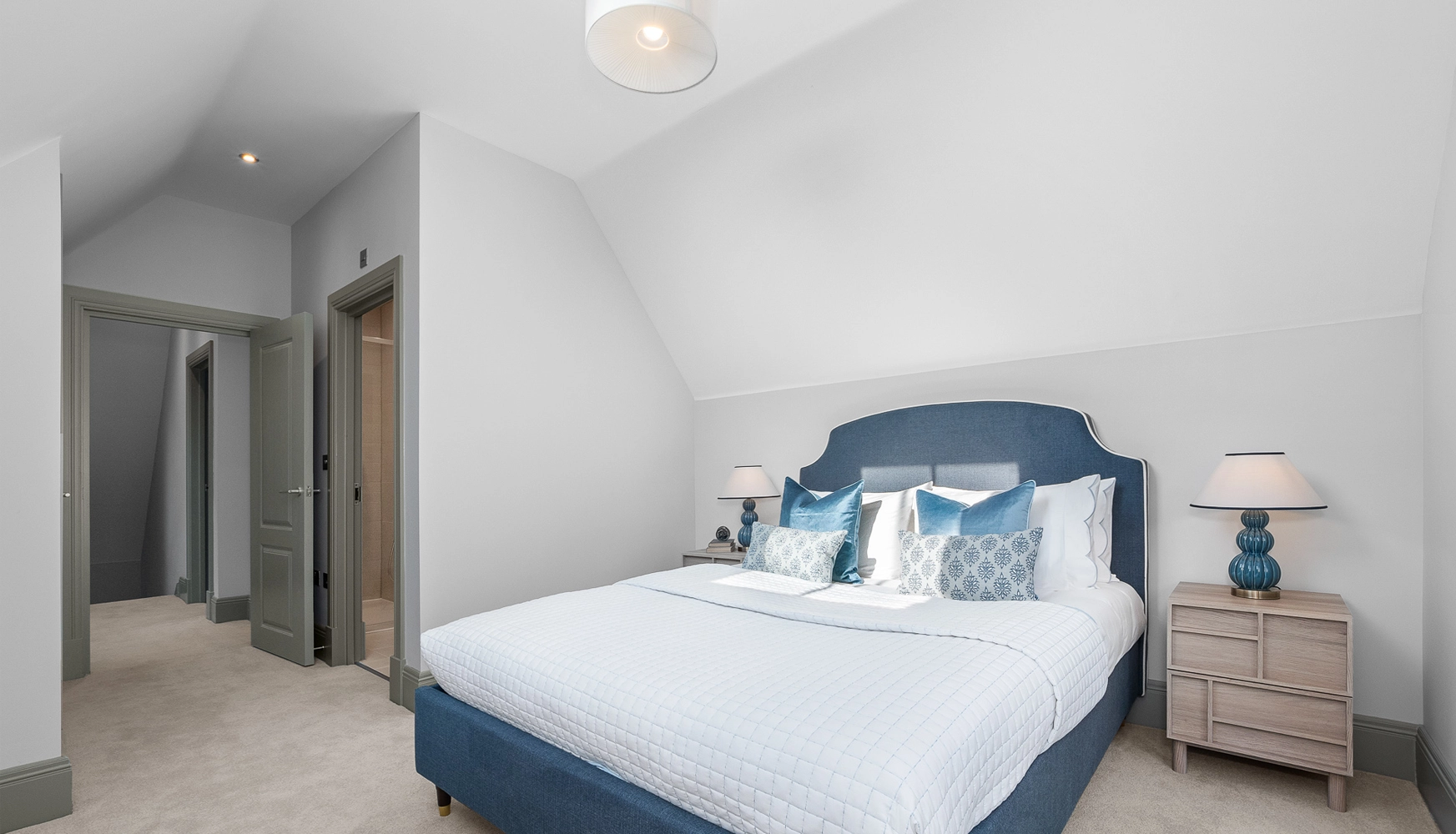 Bedroom with blue bed in the middle of the room and ensuite
