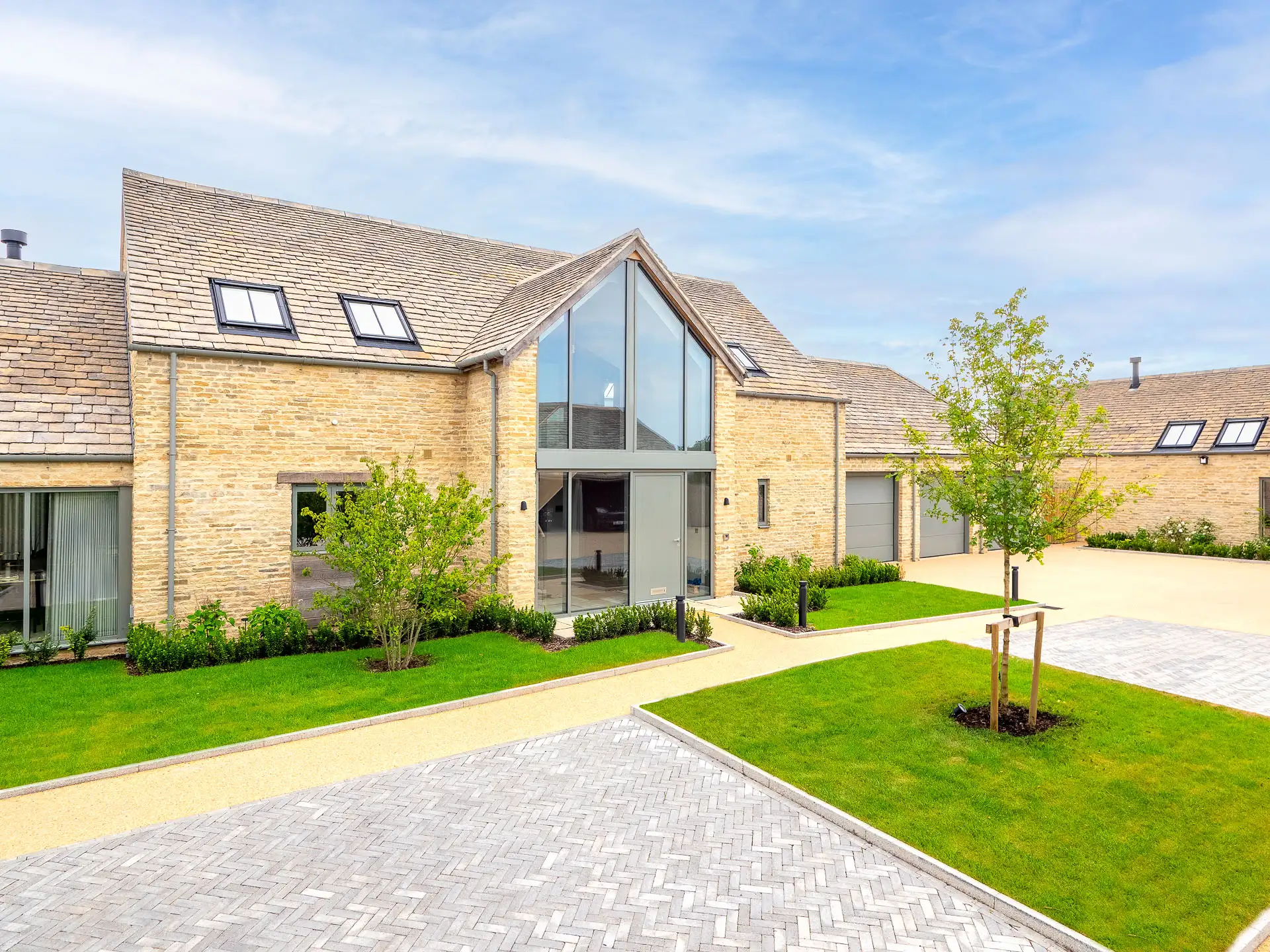 House with large glass, double height entrance and grey doors
