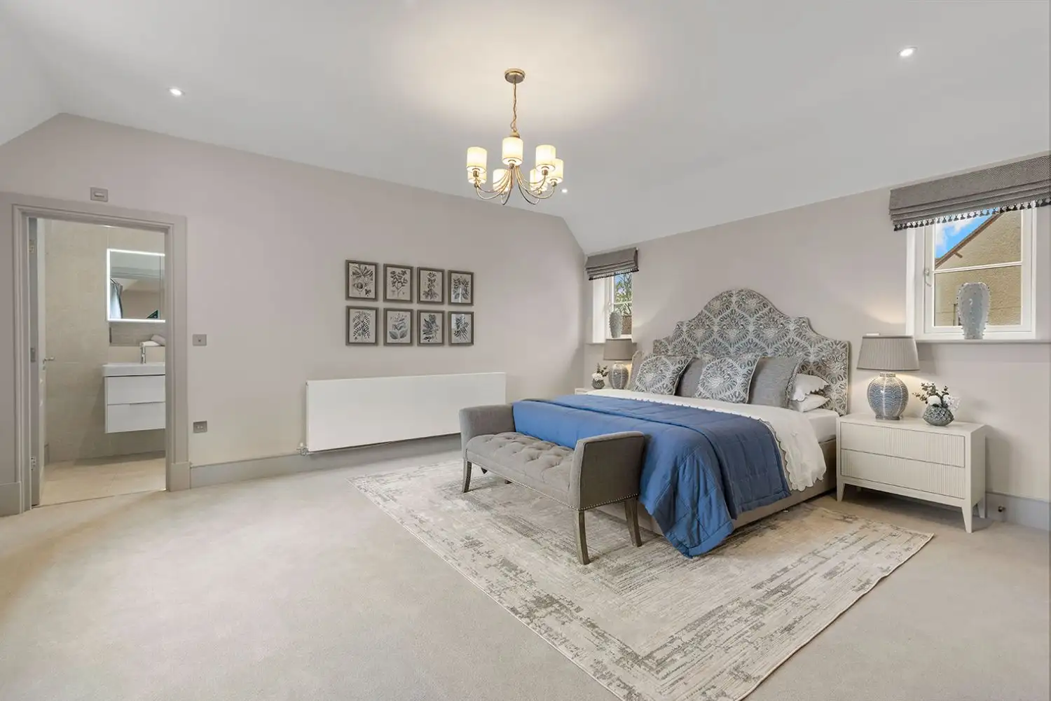 Large bedroom with two windows either side of the bed and ensuite