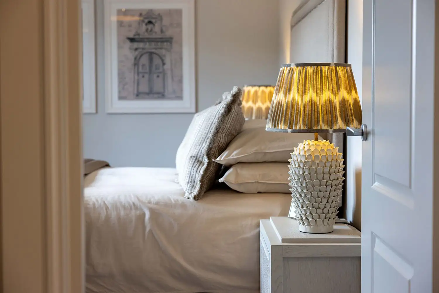 Bedroom with light bedside table and grey door