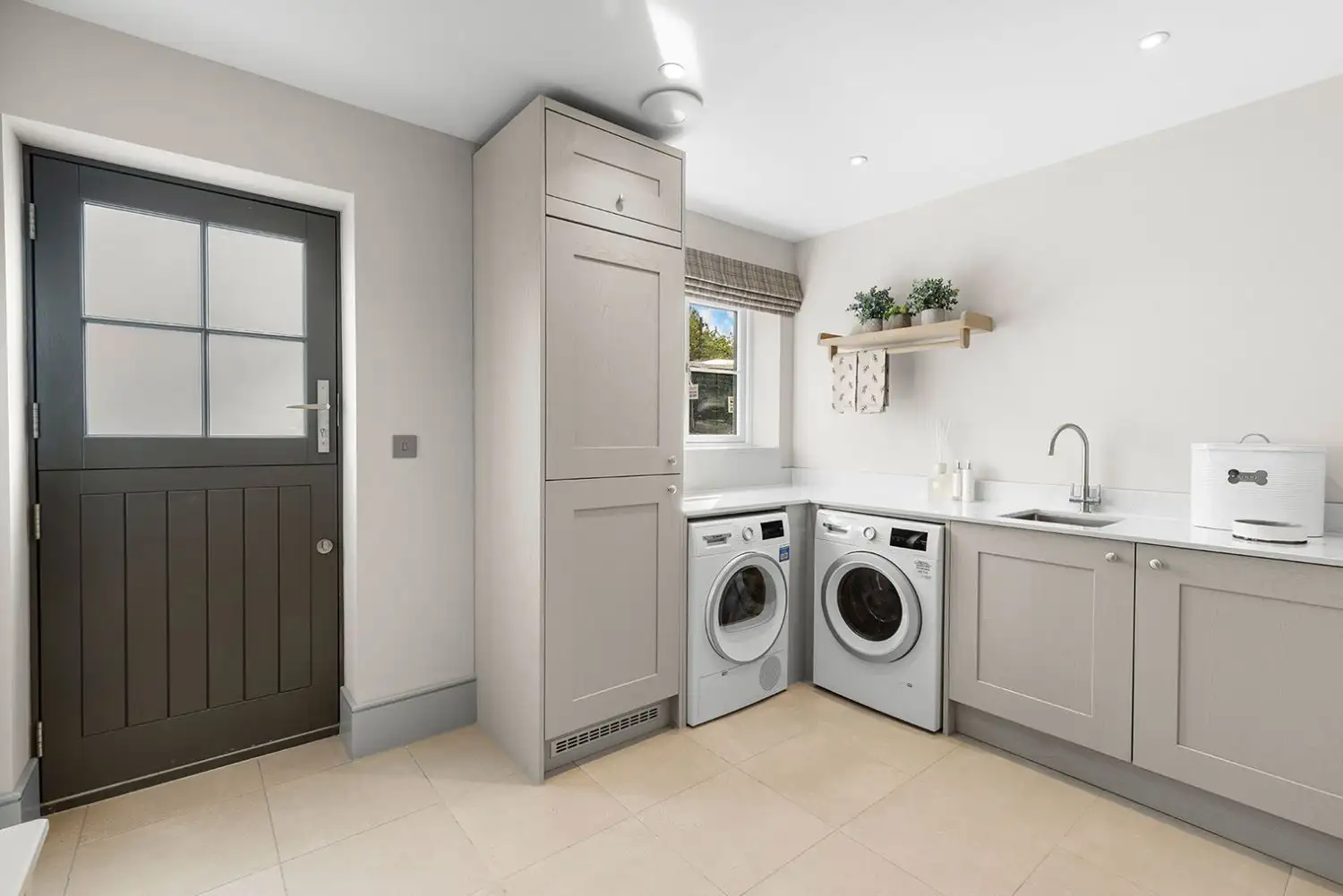 Utility room with sink and beige cupboards and stable door