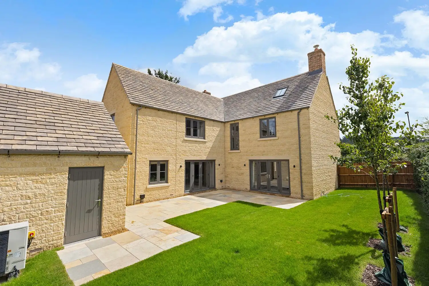 Back of house with dark grey patio doors and access to garage