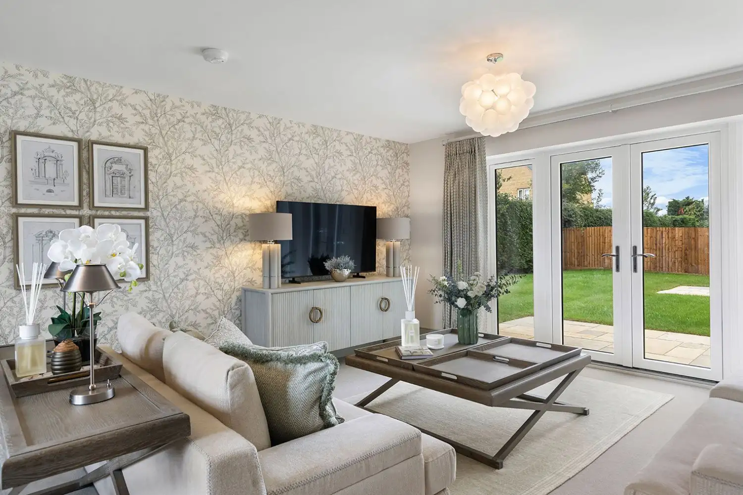 Living room with decorative wallpaper and patio doors leading to the garden
